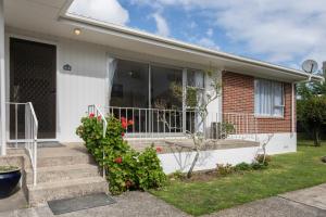 a house with a porch and stairs with flowers at Beckenham Garden in Auckland