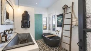 a bathroom with a bath tub and a sink at Hogans Bluff in Coopers Shoot