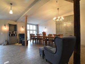 a dining room and living room with a table and chairs at Gutshofblick L in Hanshagen