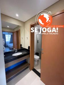 un baño con aseo y un letrero en la pared en Resort de São Pedro por Agencia se Joga pelo Mundo, en São Pedro