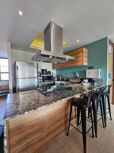 アカプルコにあるLA ISLA RESIDENCES/HERMOSO DEPAのキッチン(椅子とコンロ付きのカウンター付)