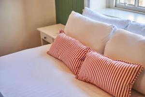 a bed with white pillows and a red and white pillow at Arlington House Hotel - Self Check-In Suites in Wooler +16 photos