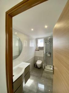 ein Badezimmer mit Waschbecken, Toilette und Spiegel in der Unterkunft Maison proche Paris, Aéroport CDG, Stade de France in Drancy