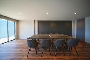 ein Esszimmer mit Tischtennisplatte und Stühlen in der Unterkunft Hub-Fun in Katsuno + 72 Fotos