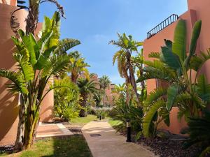 a garden with palm trees and a building at Pool, Beach and Sun in Mar Menor Golf Resort in Torre-Pacheco