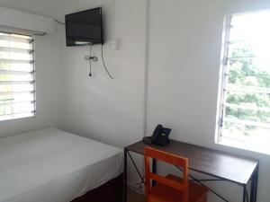 a bedroom with a desk and a bed and a television at Yatu Lau Transit Hotel in Nadi