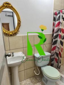 a bathroom with a toilet and a sink and a mirror at Estancia Charito Hospedaje in Iquitos