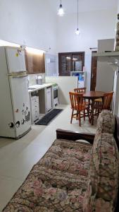 a living room and kitchen with a couch and a table at Recanto do surf in Imbituba +17 photos