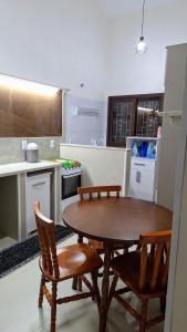 a kitchen with a wooden table and two chairs at Recanto do surf in Imbituba