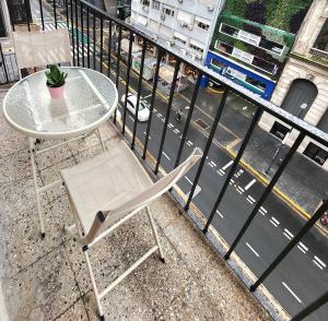 a table and a chair sitting on a balcony at Apartamento BA Obelisco in Buenos Aires