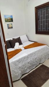 a bedroom with a large bed in a room at Recanto do surf in Imbituba