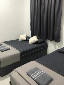 two beds sitting next to each other in a room at DyMaz Salam Homestay in Seri Iskandar