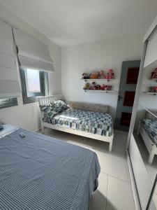 Un dormitorio con una cama y un sofá. en Apartamento com piscina, en Porto Seguro