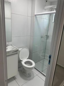 a bathroom with a toilet and a glass shower at Luar da Praia in Olinda
