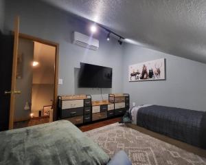 a bedroom with a bed and a flat screen tv at Shelter Chalet in Rhododendron