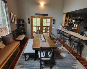 a dining room with a table and a bar at Shelter Chalet in Rhododendron