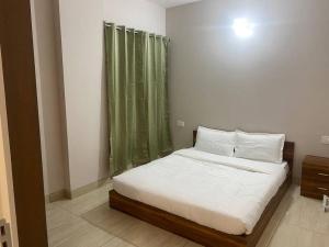 1 dormitorio con 1 cama con cortina verde en Tara Luxury Homes 2BHK, en Solan