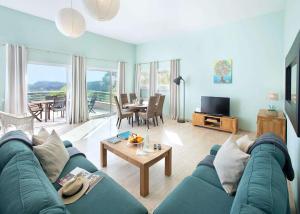 a living room with a blue couch and a table at Mar Bona in Tamariu