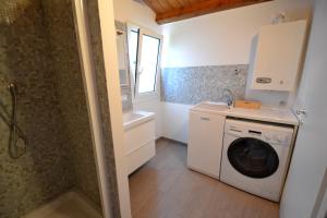 uma casa de banho com uma máquina de lavar roupa e um lavatório em Casa degli Avi Don Neli, immersa nella natura em Modica