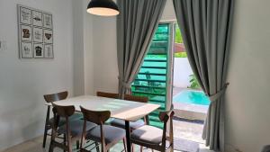 a dining room with a table and chairs and a window at The Oasis Kuantan with Private Pool in Kuantan