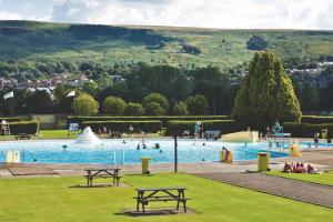 a large swimming pool with people in a park at Ilkley Garden Suite in Ilkley