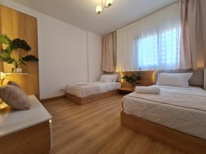 a small room with two beds and a window at Madinaty Elite Living Apartment in New cairo