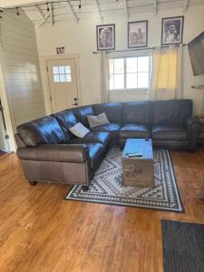 a black leather couch in a living room at Whitewater Cottage- IN TOWN walk to everything in Lava Hot Springs