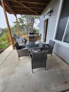 un patio con sillas, una mesa y una parrilla en L'escapade The Getaway, en Lincoln City