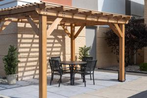 a wooden pergola with a table and chairs on a patio at Holiday Inn Express Toledo North by IHG in Toledo