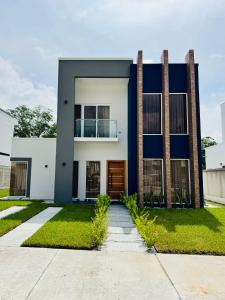 una casa con una fachada azul y blanca en Hermosa casa moderna con piscina, en San Pedro Sula
