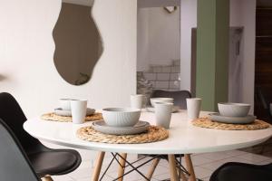 a white table with bowls and cups on top at Casa Valeria, a Slo 10 Minutos De Andares in Guadalajara