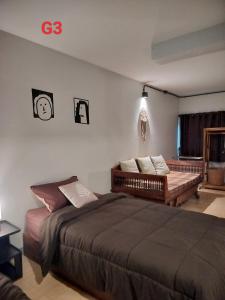 a bedroom with a large bed and a bench at Oldy De Garden in Chiang Mai