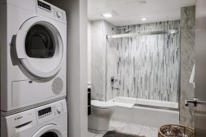 a bathroom with a washing machine and a shower at Abode Los Angeles - Downtown South Park in Los Angeles +180 photos