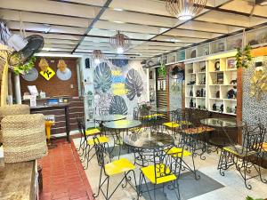 a restaurant with tables and chairs in a room at Roadway in Dalumpinas Oeste