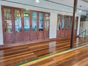 an empty bowling alley with wooden floors and windows at Baanrak amphawa homestay in Amphawa