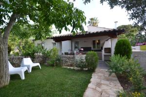 莫迪卡Casa degli Avi Don Neli, immersa nella natura的院子里两把白色椅子的房子