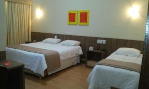 Habitación de hotel con 2 camas y pinturas en la pared en Entremares Hotel en Río de Janeiro