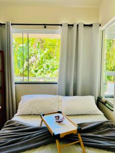 a bed with a tray on it with a window at Casa com banheira in Governador Celso Ramos