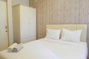 スラバヤにあるSimply Modern Studio at Pavilion Permata Apartment By Travelioの白いベッド(タオル2枚付) +4枚の写真