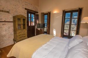 ein Schlafzimmer mit einem großen Bett und einem TV in der Unterkunft Epoches Luxury Suites in Karpenisi