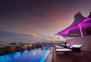 uma piscina no telhado de um edifício com luzes roxas em Senses Quinta Avenida Hotel By Artisan em Playa del Carmen