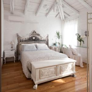 1 dormitorio blanco con 1 cama blanca y suelo de madera en Bed & Breakfast Canova, en Treviso