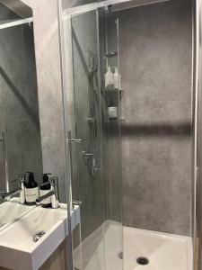 a bathroom with a glass shower and a sink at Lakeside Tiny Home in Cromwell +10 photos