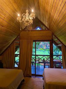 une chambre avec deux lits et un lustre dans l'établissement Laguna Lodge El Zarzal, à Valle de Ángeles