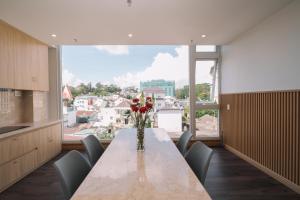 a dining room with a table and a large window at HOANG LINH PHAT HOTEL in Da Lat