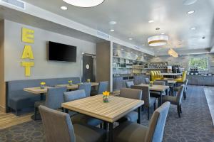 a restaurant with tables and chairs and a tv at Oxford Suites Bellingham in Bellingham