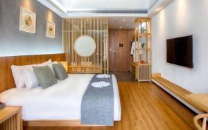 a bedroom with a large white bed and a television at Shanghai Linyin Holiday Hotel - Pudong Airport in Shanghai