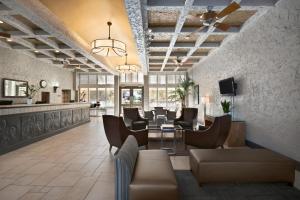 a lobby with a waiting room with tables and chairs at Motel 6 Phoenix, AZ – Sky Harbor in Phoenix
