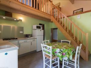 a kitchen with a table and a staircase in a house at Gîte nature & confort rénové, Plateau des 1000 étangs - WIFI, parking - FR-1-583-302 in Saint-Bresson