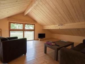 a living room with a couch and a table at Gîte nature & confort rénové, Plateau des 1000 étangs - WIFI, parking - FR-1-583-302 in Saint-Bresson